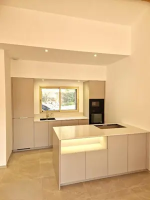 an empty kitchen with white cabinets and a window at Charming stone villa with pool in Figari