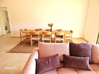 a living room with a couch and a dining room table at Charming stone villa with pool in Figari