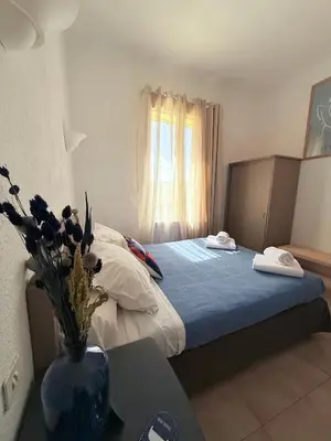 a small bedroom with a bed and a window at La Châtaigneraie in Evisa