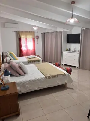 a bedroom with two beds and a dresser at Bas de villa Sarrola Carcopino in Sarrola-Carcopino