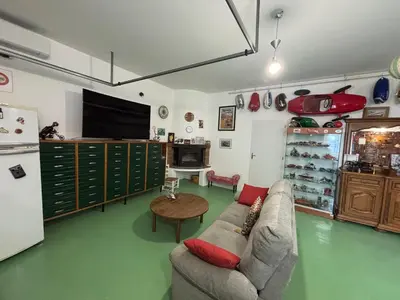 a living room with a couch and a table and a tv at Bas de villa Sarrola Carcopino in Sarrola-Carcopino