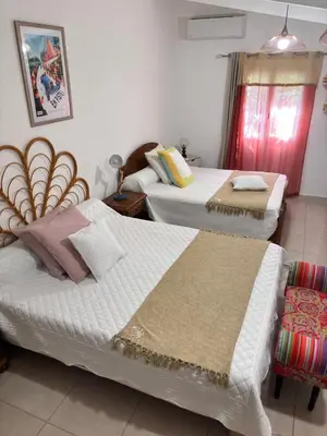 a room with two beds and a chair in it at Bas de villa Sarrola Carcopino in Sarrola-Carcopino