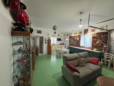 a living room with a couch in a room with wine racks at Bas de villa Sarrola Carcopino in Sarrola-Carcopino
