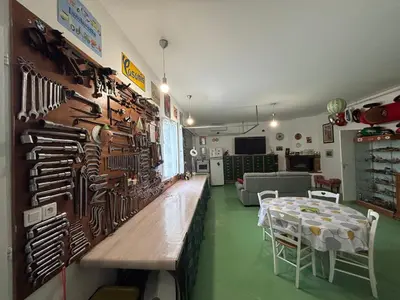 a room with a table and a wall of knives at Bas de villa Sarrola Carcopino in Sarrola-Carcopino