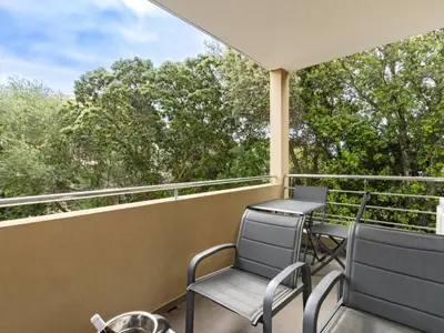 a balcony with chairs and a view of trees at Apartment Clos Vignola by Interhome in Porto-Vecchio