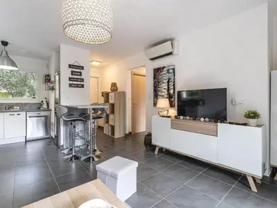 a living room with a television and a kitchen at Apartment Clos Vignola by Interhome in Porto-Vecchio