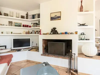 a living room with a fireplace and a tv at Holiday Home Villa Marina by Interhome in Porto-Vecchio
