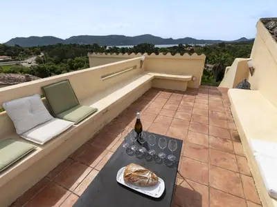 a patio with a table and chairs and a bottle of wine at Holiday Home Villa Marina by Interhome in Porto-Vecchio