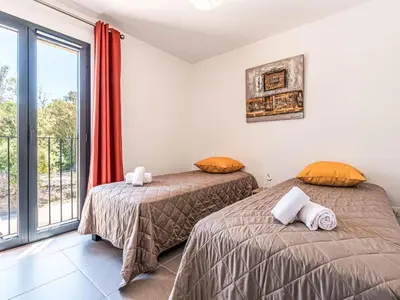 two beds in a room with a balcony at Apartment Foce Dell Edera-3 by Interhome in Bonifacio