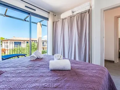 a bedroom with a purple bed with towels on it at Apartment Foce Dell Edera-3 by Interhome in Bonifacio