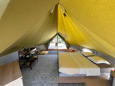 a yellow tent with a bed in a room at Le Tipi in Lecci
