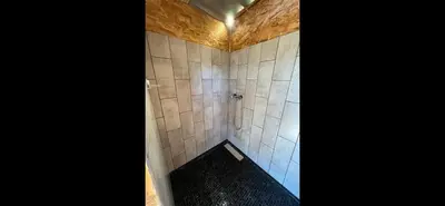 a bathroom with a shower with white tiles at Le Tipi in Lecci