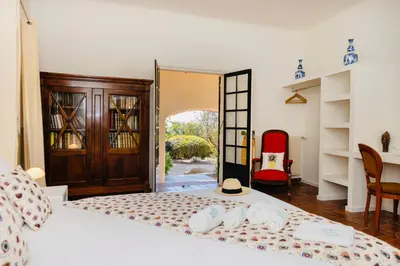 a bedroom with two beds and a door to a yard at Balamb Garden A Cinarchesa in Ajaccio