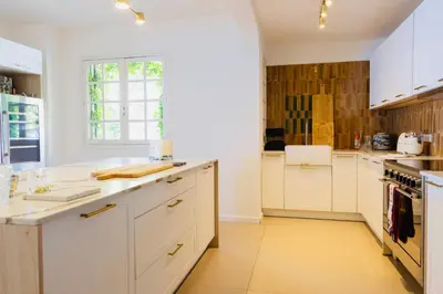 a white kitchen with white cabinets and a window at Balamb Garden A Cinarchesa in Ajaccio