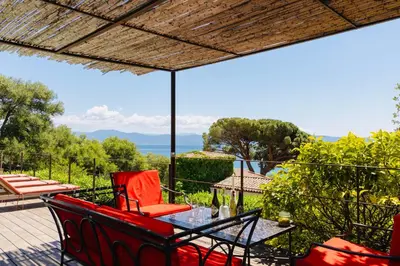 a patio with a table and chairs on a balcony at Balamb Garden A Cinarchesa in Ajaccio