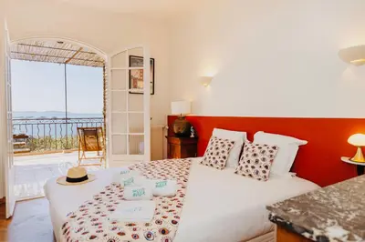 a bedroom with a bed with a view of the ocean at Balamb Garden A Cinarchesa in Ajaccio