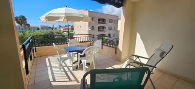a balcony with a table and chairs and an umbrella at Palmeraie 131-Clim-PISCINE EN RESIDENCE in Sari Solenzara