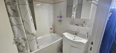 a white bathroom with a sink and a tub and a shower curtain at Palmeraie 131-Clim-PISCINE EN RESIDENCE in Sari Solenzara