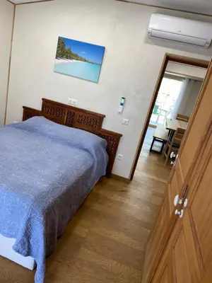 a bedroom with a bed and a sliding glass door at T2 bala in Porto-Vecchio