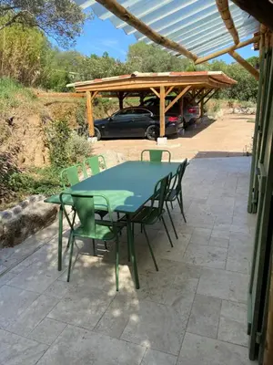 a green table and chairs on a patio at T2 bala in Porto-Vecchio