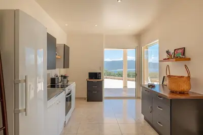 a large kitchen with a view of the ocean at Family Villa with Pool and Sublime Sea View in Olmeto