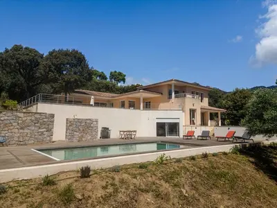 a house with a swimming pool in front of it at Family Villa with Pool and Sublime Sea View in Olmeto