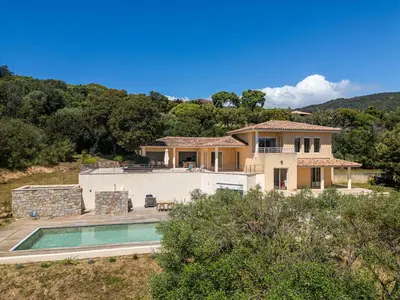 a house with a swimming pool in front of it at Family Villa with Pool and Sublime Sea View in Olmeto