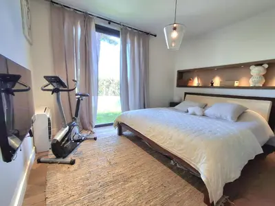a bedroom with a bed and a treadmill next to a window at Villa bord de mer avec piscine in Lucciana