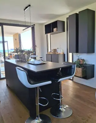 a kitchen with a bar with two stools at Villa bord de mer avec piscine in Lucciana