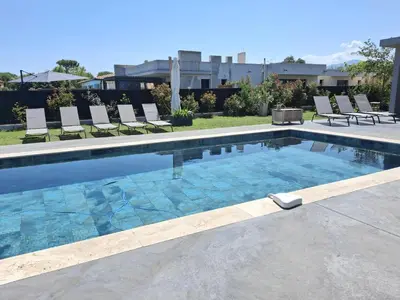 a large swimming pool with chairs at Villa bord de mer avec piscine in Lucciana