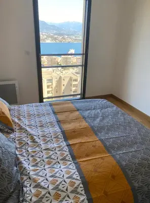 a bedroom with a bed with a large window at Salario-1 in Ajaccio