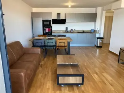 a living room with a couch and a kitchen at Salario-1 in Ajaccio