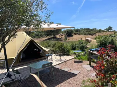 a tent with a table and chairs in a yard at Le Tipi 2 in Lecci