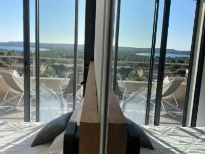 a bedroom with a bed and a window with chairs at La résidence Location Pinarello in Mangialla