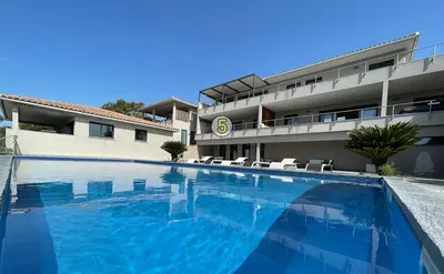 a large swimming pool in front of a building at La résidence Location Pinarello in Mangialla