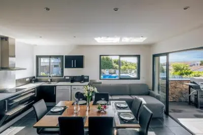 a living room with a table and a kitchen at La résidence Location Pinarello in Mangialla