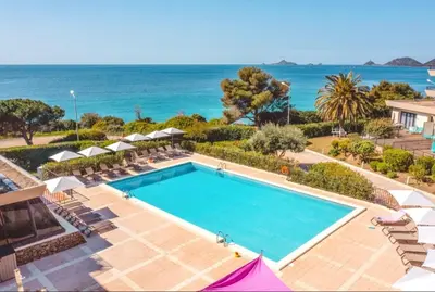 a swimming pool with the ocean in the background at Beau Studio vue sur mer, route des sanguinaires in Ajaccio