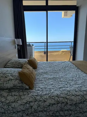 a bedroom with a bed with a view of the ocean at Beau Studio vue sur mer, route des sanguinaires in Ajaccio