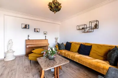 a living room with a couch and a piano at Le Renoso - Climatisé vue mer et montagne in Ajaccio