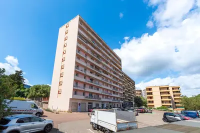 a tall building with a truck parked in a parking lot at Le Renoso - Climatisé vue mer et montagne in Ajaccio