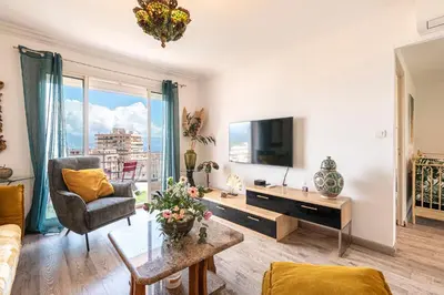 a living room with a couch and a tv at Le Renoso - Climatisé vue mer et montagne in Ajaccio