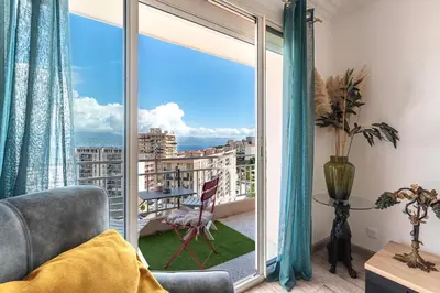 a room with a large window with a view of the city at Le Renoso - Climatisé vue mer et montagne in Ajaccio