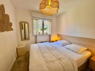 a bedroom with a large bed and a window at Deux pièces tout confort sur les hauteurs de Propriano in Propriano