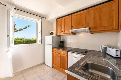 a kitchen with a sink and a window at Prunete - Piscine - Vue mer in Cervione