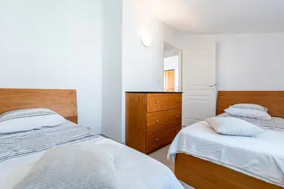 a bedroom with two beds and a dresser and a mirror at Prunete - Piscine - Vue mer in Cervione
