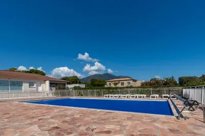 a swimming pool with chairs and a fence at Prunete - Piscine - Vue mer in Cervione