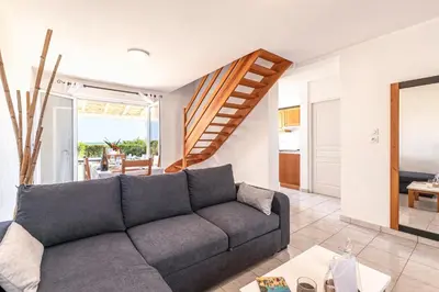 a living room with a couch and a staircase at Prunete - Piscine - Vue mer in Cervione