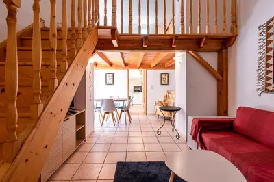 a living room with a red couch and wooden stairs at Appartement cosy - Hyper centre-ville in Ajaccio