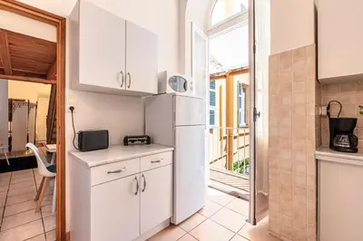 a kitchen with white cabinets and a refrigerator at Appartement cosy - Hyper centre-ville in Ajaccio