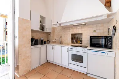 a kitchen with white cabinets and a microwave at Appartement cosy - Hyper centre-ville in Ajaccio